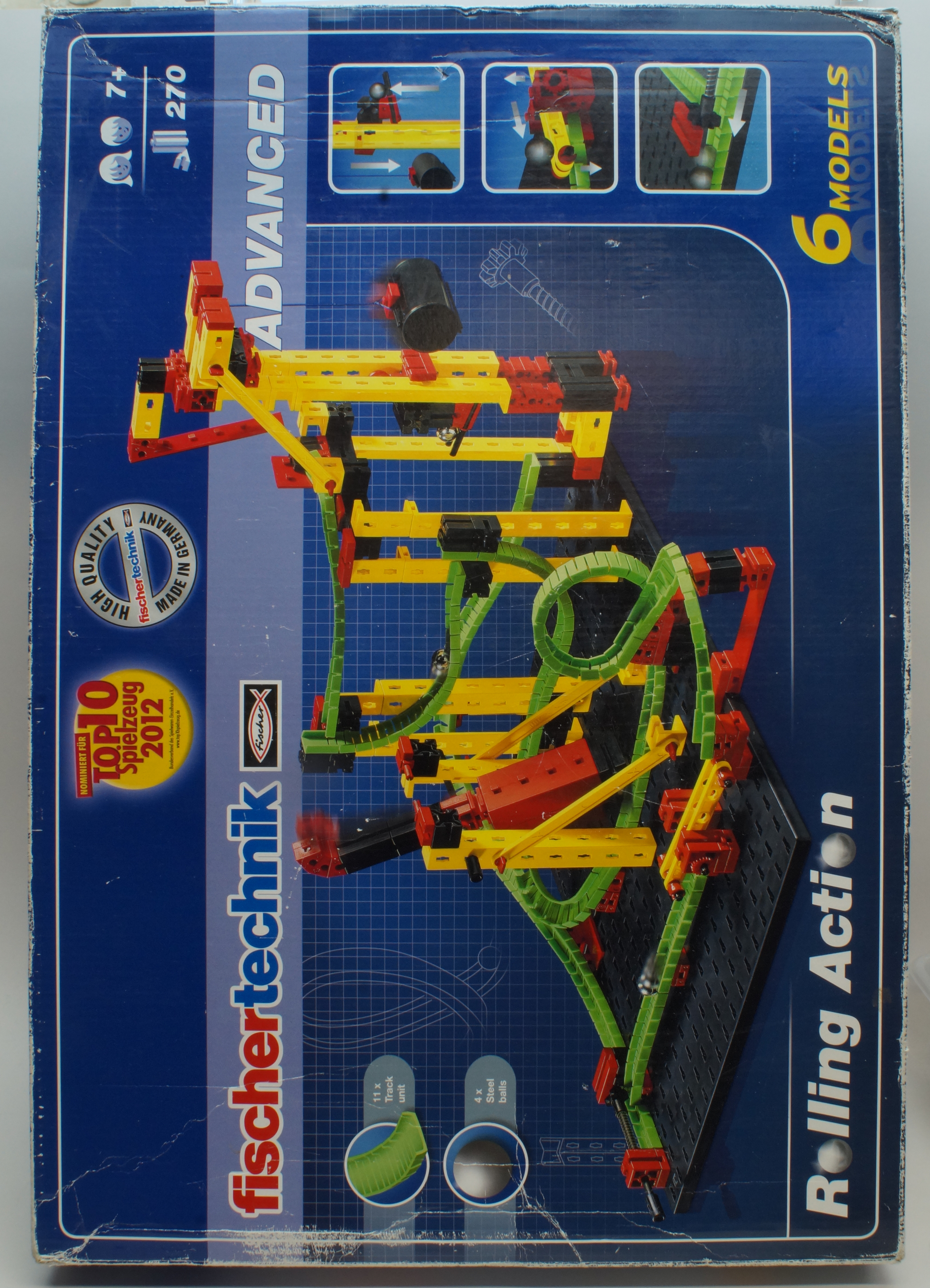 Advanced Kugelbahn Rolling Action - vollständig Eine fischertechnik Rolling Action Baukastenbox mit einem gelb-roten Kugelbahnmodell auf blauem Hintergrund.